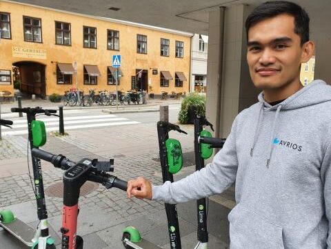 Ett foto på Phil Flores som håller i en elsparkcykel.